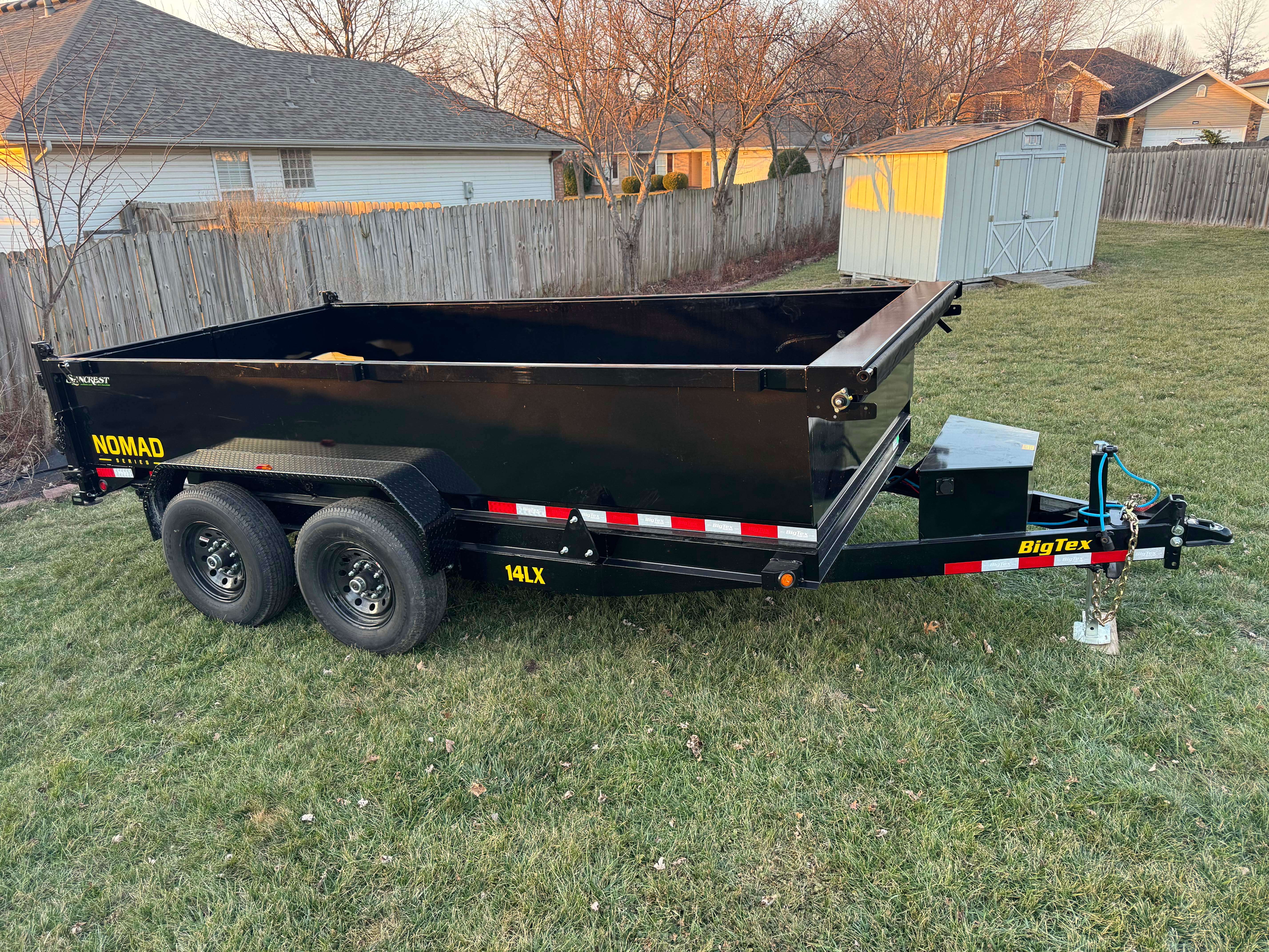 BigTex Nomad Dump Trailer in a green field at sunset
